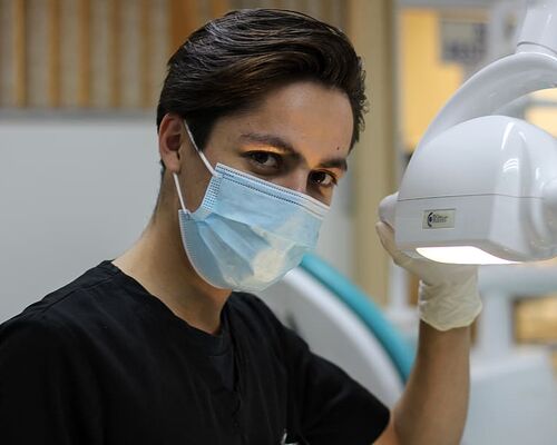 man-with-mask-holding-dental-glass