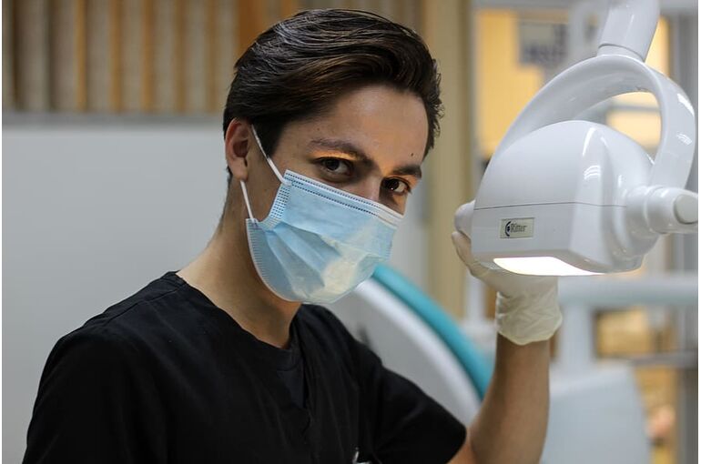 man-with-mask-holding-dental-glass